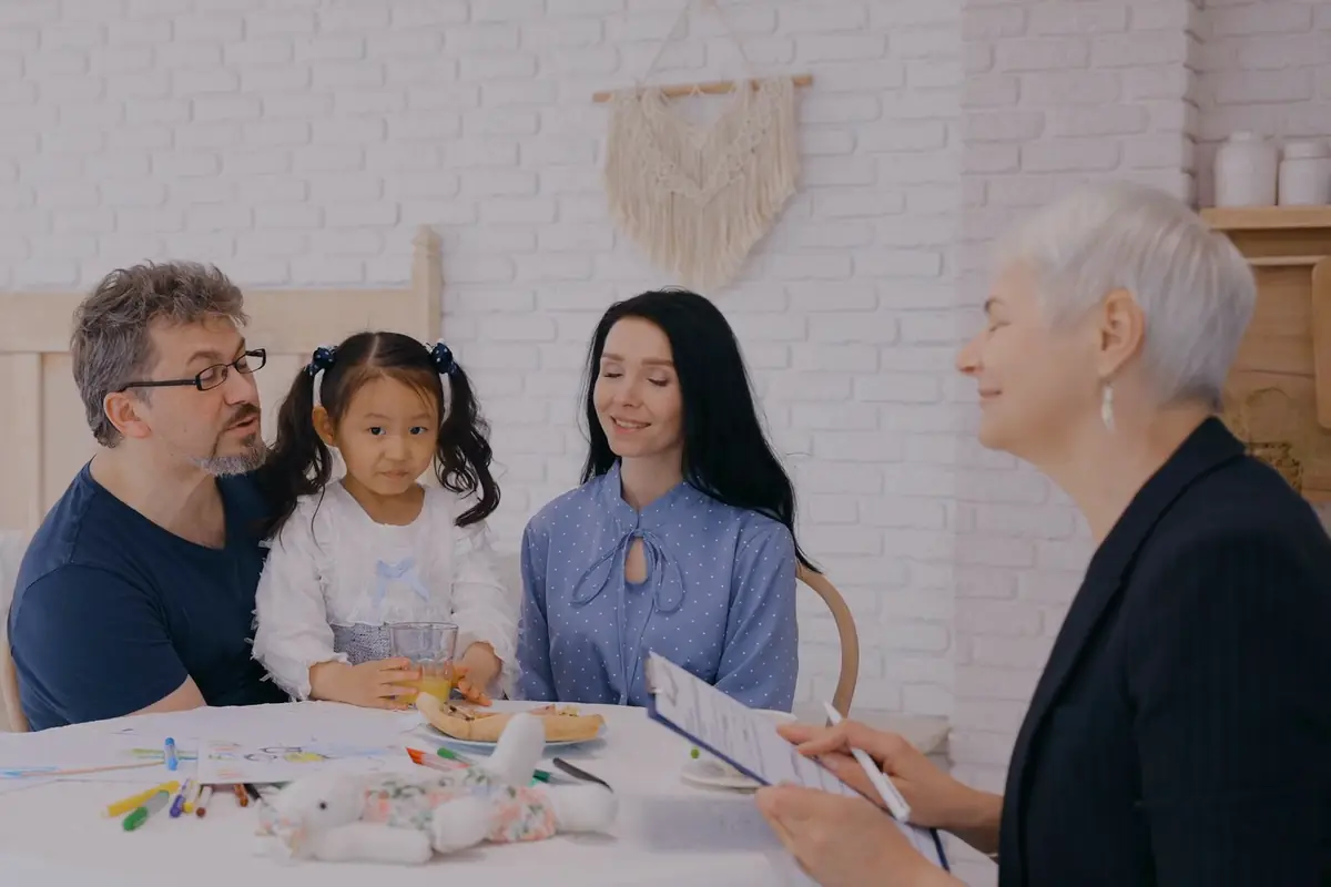 A practitioner talking with a mother, father and young child at home